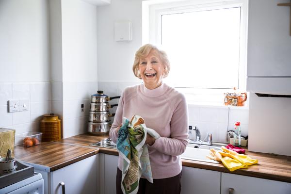 Senior lady laughing in kitchen