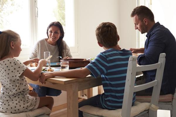 Family eating a meal together around a table