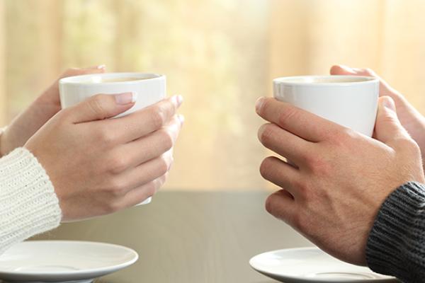 Two people drinking hot drinks