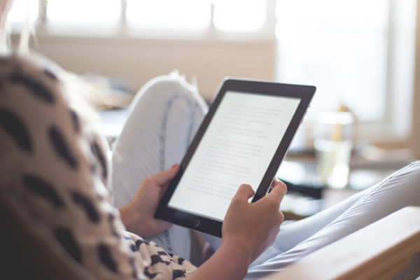 person reading a book on a tablet